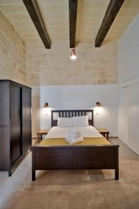 a bedroom with a large bed in a room at Vallettastay Old Lodge Apartment 3 in Valletta