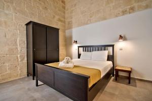 a bedroom with a large bed in a room at Vallettastay Old Lodge Apartment 3 in Valletta