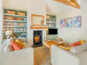 a living room with two white couches and a fireplace at Windover Barn in Slinfold