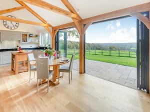 a kitchen and dining room with a table and chairs at Windover Barn in Slinfold