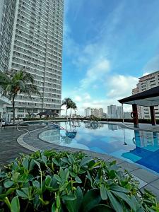 a large swimming pool in front of a large building at The Beacon Residences Condominium in Manila