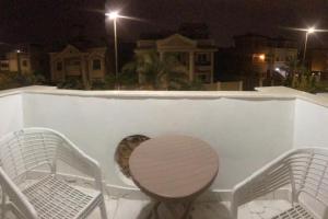 a table and chairs on a balcony at night at شقة فندقية بغرفتين قرب مول مصر وميدان جهينة families only in Sheikh Zayed