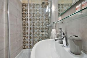 bagno con lavandino bianco e doccia di Vallettastay Old Lodge Apartment 4 a La Valletta