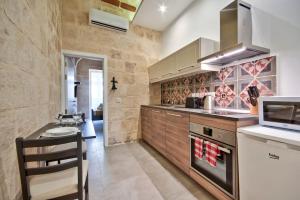 a kitchen with a counter and a stove top oven at Vallettastay Old Lodge Apartment 4 in Valletta