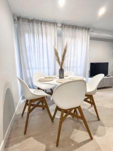 uma sala de jantar com uma mesa e cadeiras brancas em AZ El Balcón de Plaza Sas em Saragoça