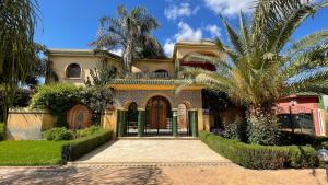 a house with a palm tree and a driveway at Riad Noumidya in Fez