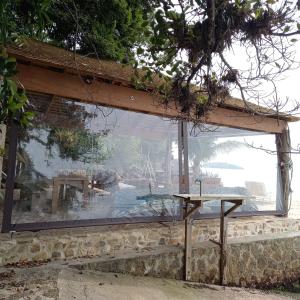 una grande finestra di vetro sul lato di un edificio di REFUGIO na frente do mar em Ilha de Araujo a Parati