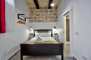 a bedroom with a bed with a wooden table at Vallettastay Old Lodge Studio 5 in Valletta
