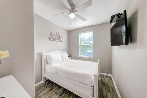 a white bedroom with a bed and a ceiling fan at Beach Way Mermaid Cove in Padre Island