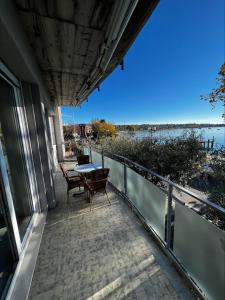 バルドリーノにあるFront Lake Apartment Bardolinoの水辺の景色を望むバルコニー(テーブル、椅子付)