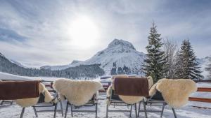 レッヒにあるホテル ＆ シャレー ベルビューの雪山の椅子群