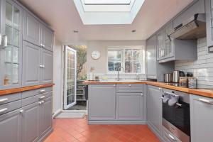 a kitchen with gray cabinets and a skylight at Windlass Cottage in Lymington