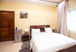 a bedroom with a large white bed and a window at Rushmore - Premier 2 Room in Lagos +8 photos