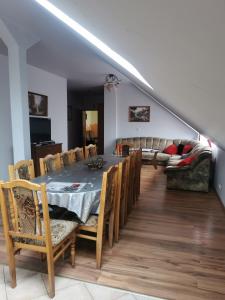 ein Esszimmer mit einem Tisch, Stühlen und einem Sofa in der Unterkunft Pokoje Gościnne Agnes in Sanok