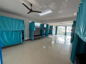 Soul, Varkala - Black Beach في فاركَالا: غرفة مع ستائر زرقاء ومروحة سقف