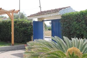 una puerta azul en un jardín con un seto en Villa Miramare, en Pontecagnano Faiano
