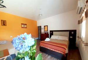 - une chambre avec un lit et une fleur bleue dans l'établissement Hostal Sisabel, à Tinogasta