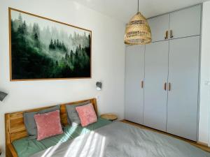 1 dormitorio con 1 cama y una pintura en la pared en Apartmán Plešivec u sjezdovky en Abertamy