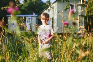 a young child standing in a field of tall grass at Snowdonia Shepherds' Huts in Conwy