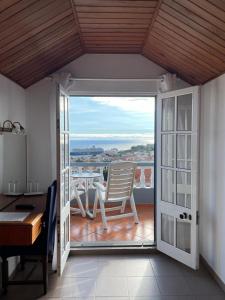 a room with a balcony with a table and a chair at Valhalla Panorama - the old Residencial Pina in Funchal