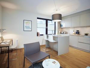 a kitchen and living room with a table and chairs at ipartment Frankfurt Europaviertel in Frankfurt/Main