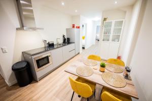 a kitchen with a wooden table and yellow chairs at Great 95m2 Two-Bedroom Apartment - WE39 in Tiel