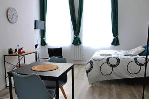sypialnia z łóżkiem, stołem i krzesłami w obiekcie Location Tame w mieście Douai