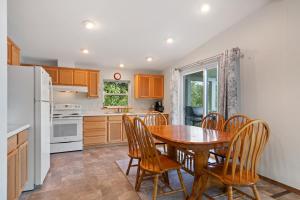 a kitchen with a table and chairs and a refrigerator at Sandy Beach at Cocolalla in Cocolalla +14 photos