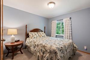 a bedroom with a bed and a table with a lamp at Sandy Beach at Cocolalla in Cocolalla