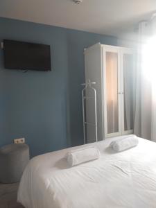 ein Schlafzimmer mit einem Bett mit zwei Handtüchern darauf in der Unterkunft Punta Carnero Hostal in Algeciras