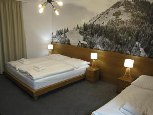 ヴァルチャにあるApartmány 45 Valčaのベッドルーム1室(ベッド2台付)が備わります。壁には絵画が飾られています。
