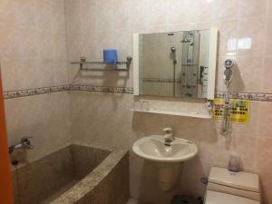 ein Badezimmer mit einer Badewanne, einem Waschbecken und einem WC in der Unterkunft Country Homestay in Guoxing