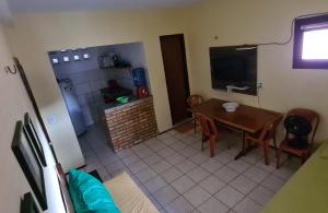 cocina y comedor con mesa y TV en Apartamento 06 - na Praia do Futuro com piscina. en Fortaleza