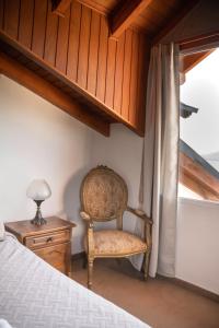 1 dormitorio con silla junto a una ventana en Departamento Las 3 Marías en San Carlos de Bariloche