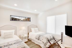 een witte slaapkamer met 2 bedden en een televisie bij Sunlight Retreat in Steamboat Springs