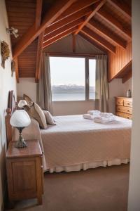 ein Schlafzimmer mit einem Bett und einem großen Fenster in der Unterkunft Departamento Las 3 Marías in San Carlos de Bariloche
