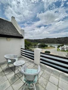 a patio with chairs and tables and a fence at Living The Breede - Sanborg in Malgas
