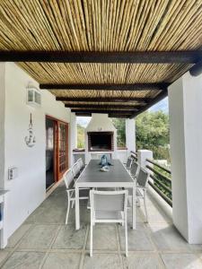 a dining table and chairs under a wooden ceiling at Living The Breede - Sanborg in Malgas