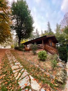 eine Blockhütte im Wald mit einem Weg davor in der Unterkunft 2 bedrooms chalet with sauna enclosed garden and wifi at Castell'Arquato in CastellʼArquato