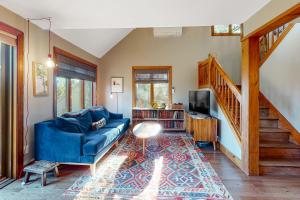 a living room with a blue couch and a staircase at Saltbox 2A in Quechee