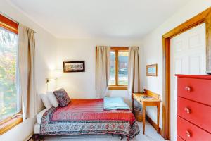 Un dormitorio con una cama con una cómoda roja y una ventana en Saltbox 12A, en White River Junction
