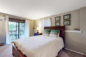 - une chambre avec un grand lit et un balcon dans l'établissement Dartmouth Place Retreat, à White River Junction