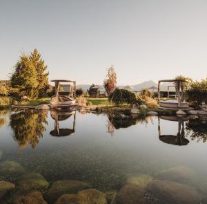 a garden with a pond with two at Hotel Chalet Mirabell in Avelengo