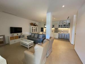 sala de estar con 2 sillas blancas y sofá en Apartamento con jardín y piscina en Córdoba, en Córdoba