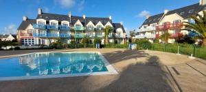 a large building with a swimming pool in front of it at Cap Marine 8 in Le Guilvinec