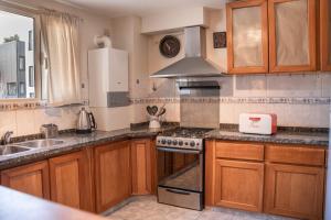 eine Küche mit Holzschränken und einem Herd mit Backofen in der Unterkunft Departamento Las 3 Marías in San Carlos de Bariloche