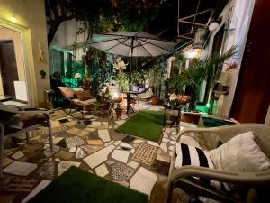 een kamer met een patio met stoelen en een parasol bij Hotel Maria in Tbilisi City