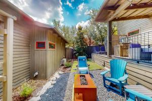 un patio con 2 sillas azules y una mesa en Riverbend Cabin #014, en Spicewood