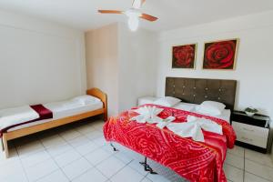 a bedroom with two beds and a ceiling fan at Centro dos Canyons Hotel in Praia Grande