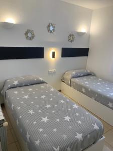 two beds in a room with stars on the wall at Pis Cala Tere in Cadaqués